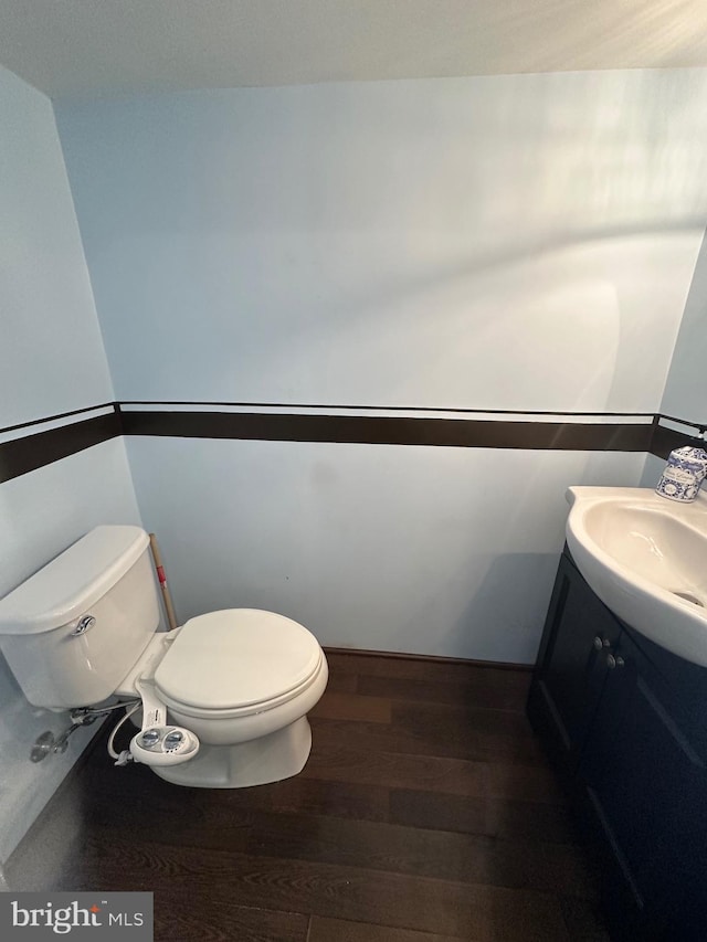 bathroom with wood-type flooring, toilet, and vanity