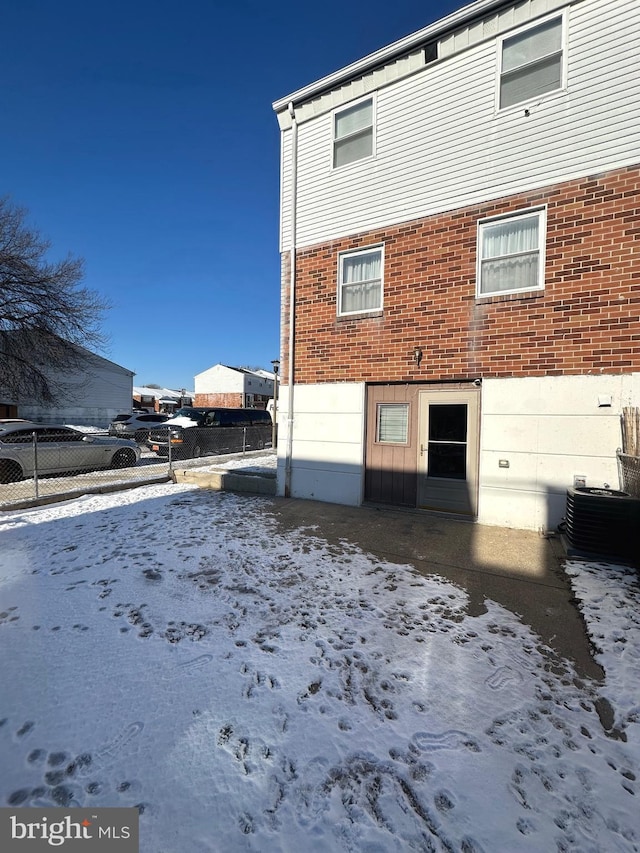 snow covered property featuring central AC unit