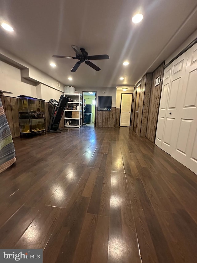 unfurnished living room featuring ceiling fan and dark hardwood / wood-style floors