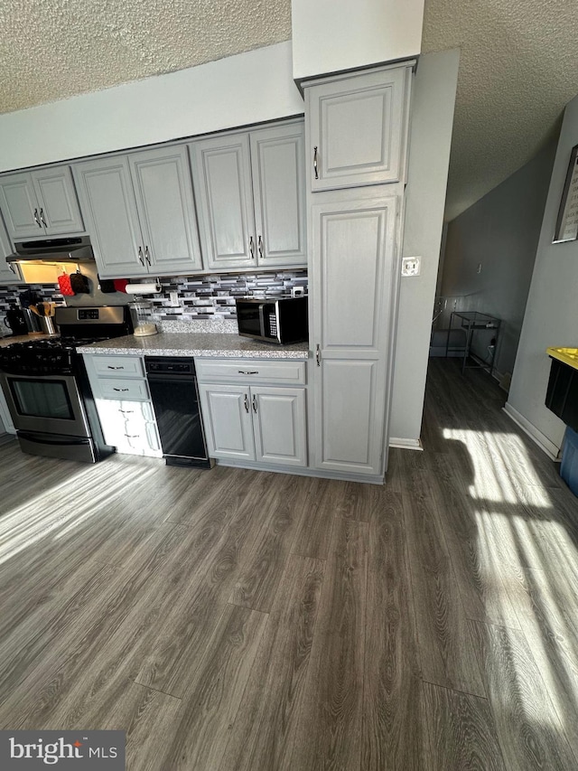 kitchen featuring a textured ceiling, backsplash, stainless steel appliances, dark hardwood / wood-style floors, and gray cabinets