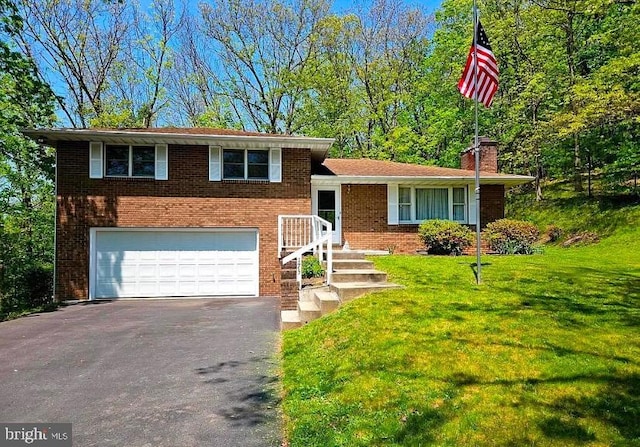 tri-level home with a front yard and a garage