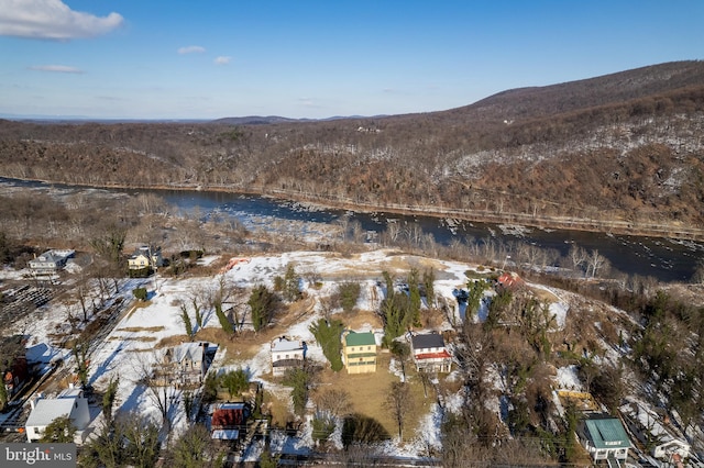 snowy aerial view with a water and mountain view