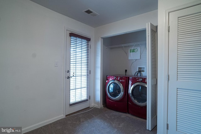 laundry area featuring washing machine and clothes dryer, plenty of natural light, and dark colored carpet