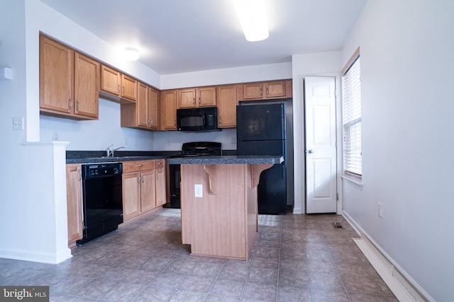 kitchen featuring a center island, a breakfast bar, and black appliances