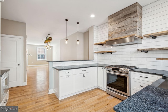 kitchen featuring white cabinetry, decorative light fixtures, appliances with stainless steel finishes, kitchen peninsula, and backsplash