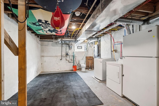 basement featuring white refrigerator and independent washer and dryer