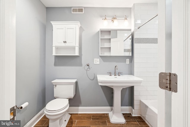 bathroom with toilet and tiled shower / bath combo