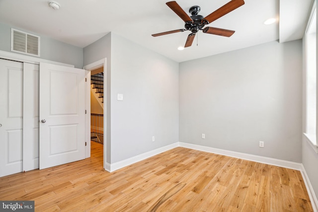 unfurnished bedroom with light hardwood / wood-style flooring, a closet, and ceiling fan