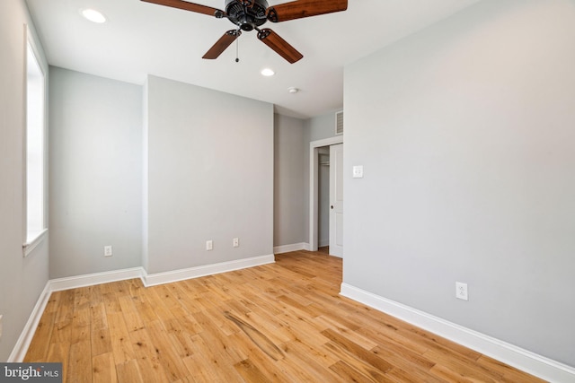 empty room featuring ceiling fan, a healthy amount of sunlight, and light wood-type flooring