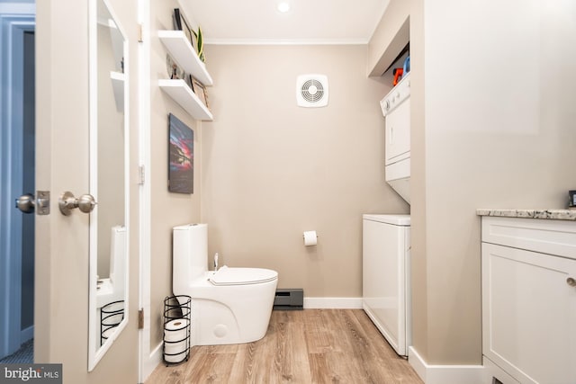 bathroom with toilet, crown molding, wood-type flooring, a baseboard radiator, and vanity