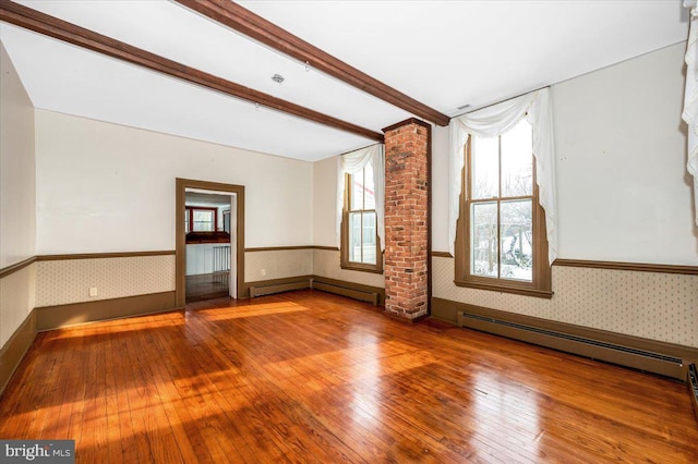 unfurnished room with a baseboard heating unit and hardwood / wood-style flooring