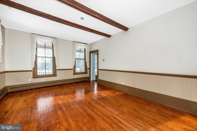 unfurnished room with beamed ceiling, wood-type flooring, and a baseboard heating unit