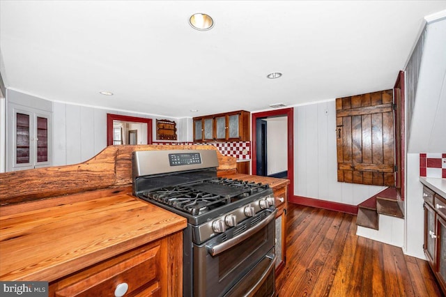 kitchen featuring dark hardwood / wood-style floors, range with two ovens, and wood walls