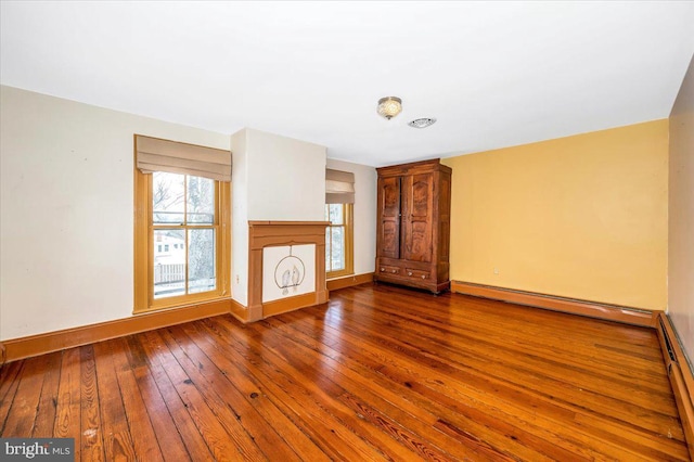 unfurnished living room with a fireplace, a baseboard radiator, and dark hardwood / wood-style floors