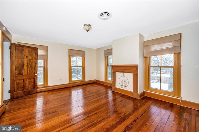 unfurnished living room featuring hardwood / wood-style floors and a baseboard radiator