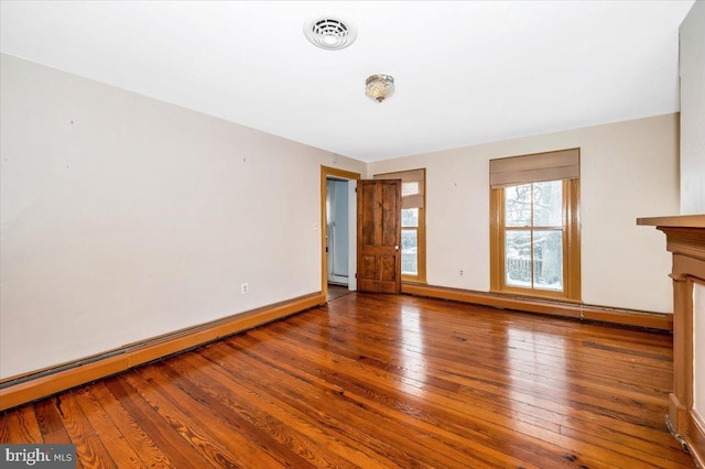 interior space with wood-type flooring and a baseboard heating unit