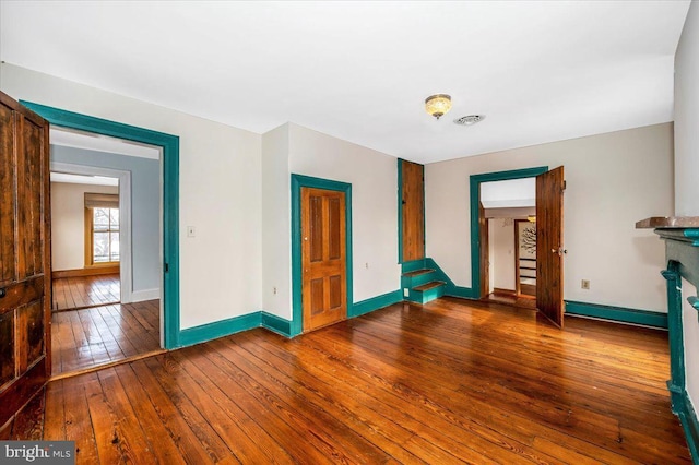 spare room with hardwood / wood-style flooring, a fireplace, and baseboard heating