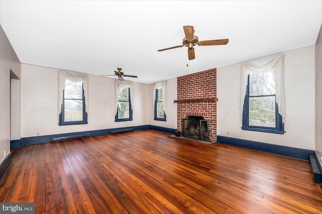 unfurnished living room featuring dark hardwood / wood-style flooring and a brick fireplace