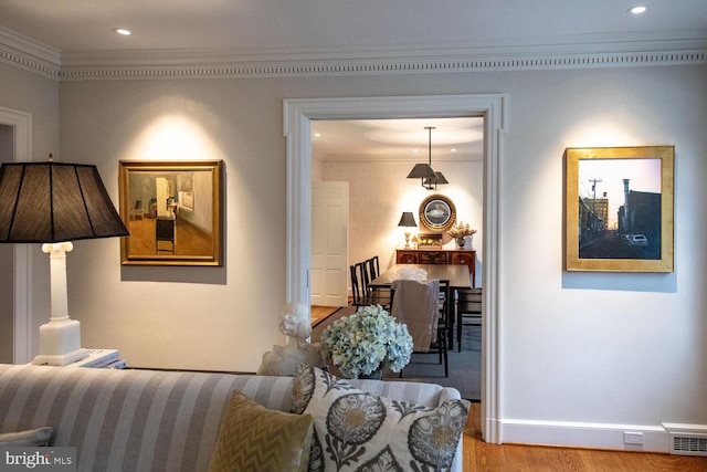 living room featuring hardwood / wood-style floors and crown molding