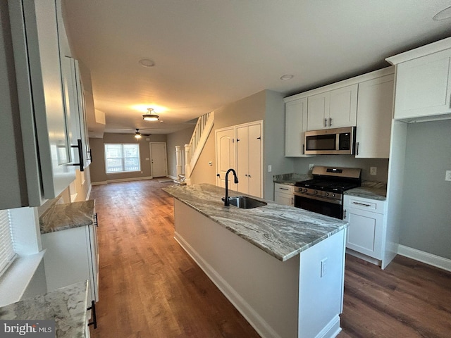 kitchen with sink, white cabinetry, light stone countertops, and appliances with stainless steel finishes