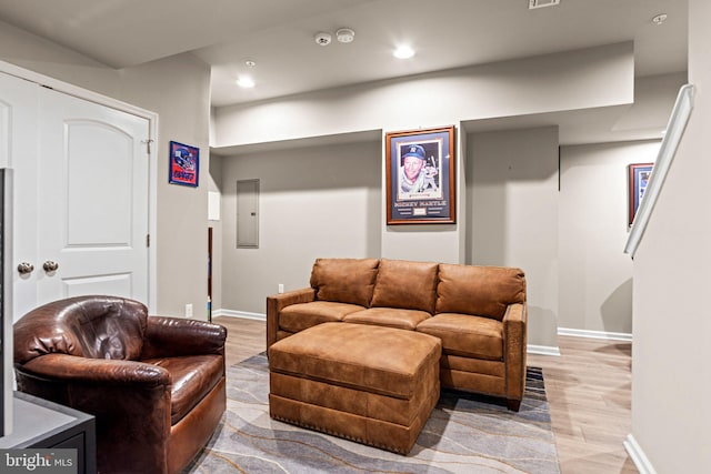 living room with electric panel and light hardwood / wood-style floors