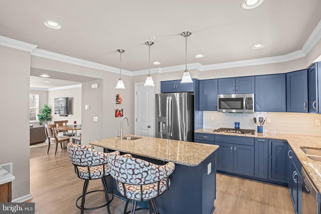 kitchen with sink, a kitchen breakfast bar, a kitchen island, stainless steel appliances, and light stone countertops