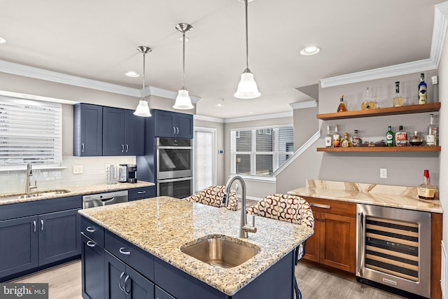 kitchen featuring wine cooler, appliances with stainless steel finishes, a kitchen island with sink, and sink