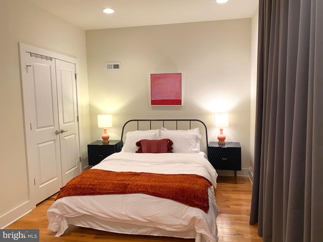 bedroom with light hardwood / wood-style floors and a closet