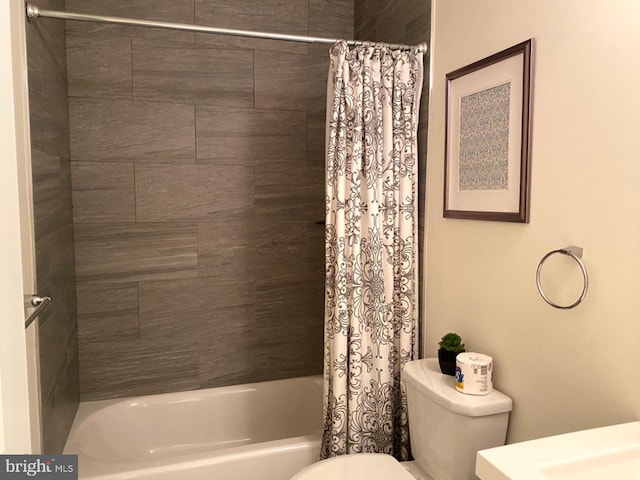 bathroom featuring shower / bath combo with shower curtain and toilet