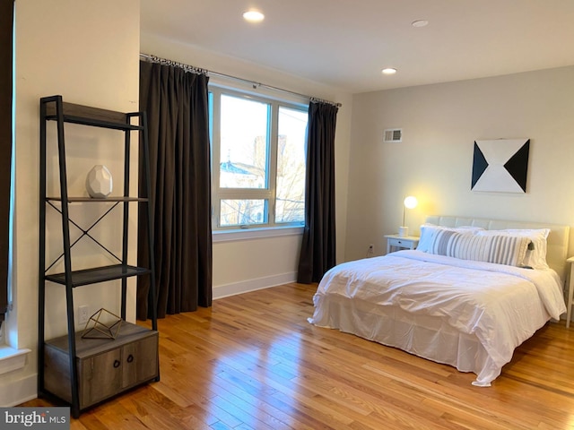 bedroom with light hardwood / wood-style flooring and multiple windows