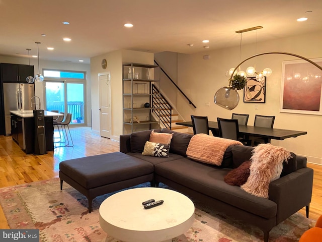 living room with light wood-type flooring and a notable chandelier