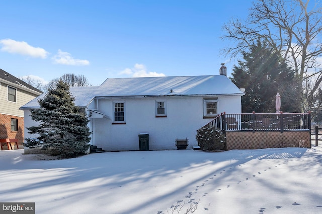 snow covered property with a wooden deck and central AC