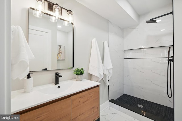 bathroom featuring a tile shower and vanity