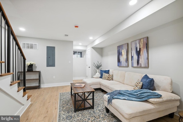 living room with light hardwood / wood-style floors and electric panel