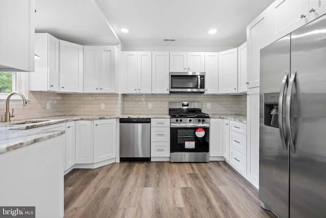 kitchen with white cabinetry, sink, backsplash, and appliances with stainless steel finishes