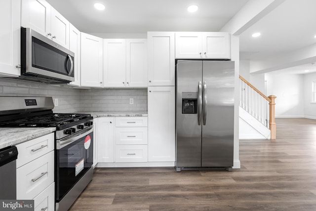 kitchen with white cabinetry, appliances with stainless steel finishes, and light stone counters