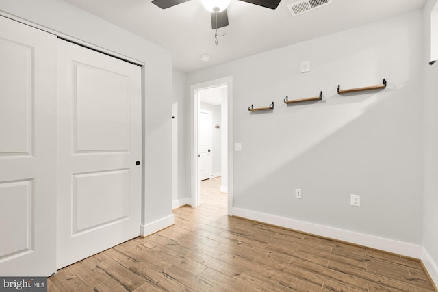 unfurnished bedroom featuring light wood-type flooring, a closet, and ceiling fan