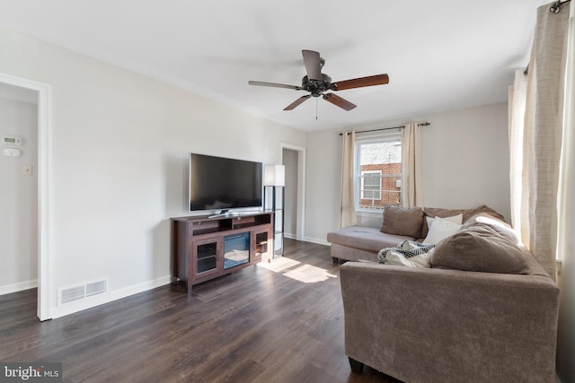 living room with ceiling fan and dark hardwood / wood-style flooring