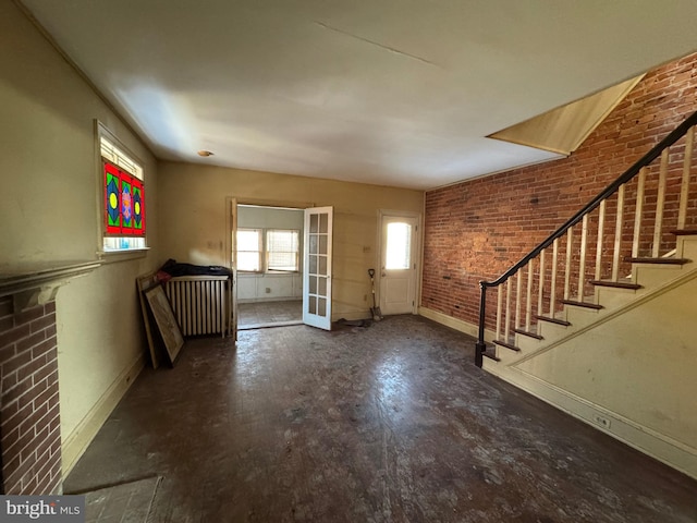 entrance foyer featuring french doors and brick wall