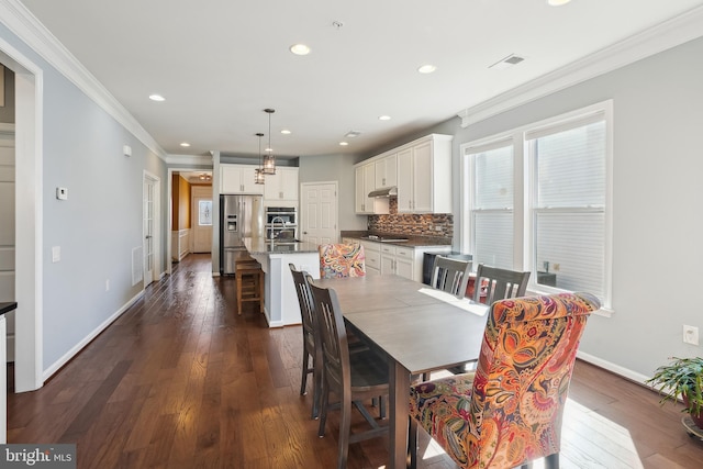 dining space featuring crown molding, dark hardwood / wood-style flooring, and sink