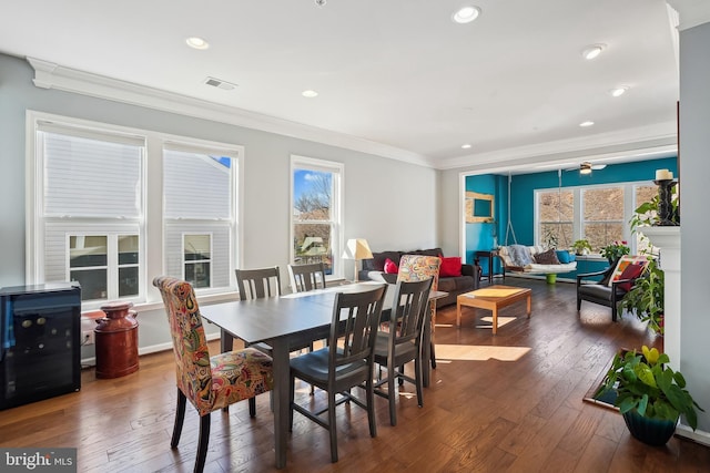 dining space with ornamental molding, wine cooler, and dark hardwood / wood-style flooring