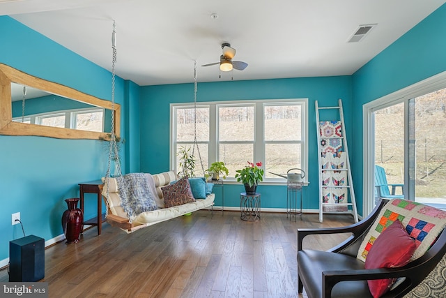 living area featuring dark wood-type flooring and ceiling fan