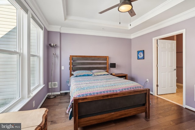 bedroom featuring hardwood / wood-style flooring, ornamental molding, and a tray ceiling