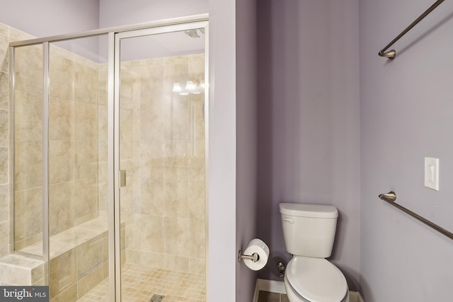 bathroom featuring toilet and a shower with shower door