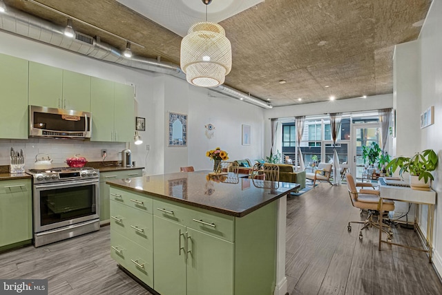 kitchen with appliances with stainless steel finishes, a kitchen island, tasteful backsplash, light hardwood / wood-style floors, and green cabinets