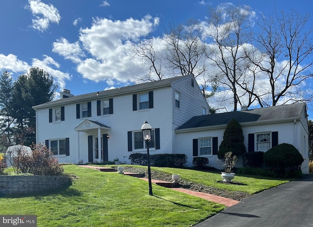 colonial inspired home featuring a front lawn