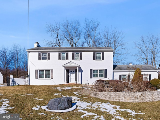 colonial-style house with a lawn