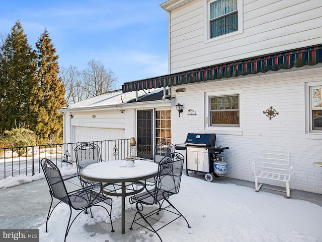 snow covered patio featuring grilling area