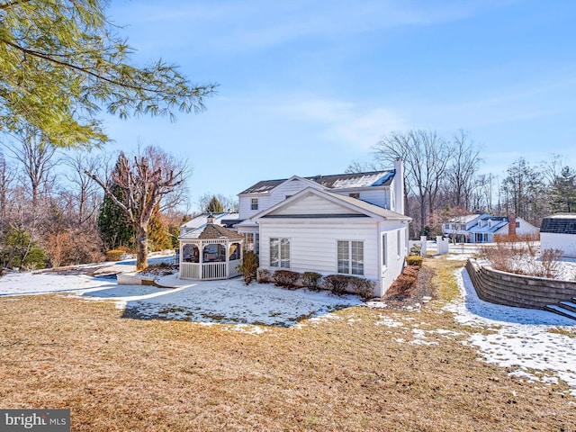 view of side of property featuring a gazebo and a lawn