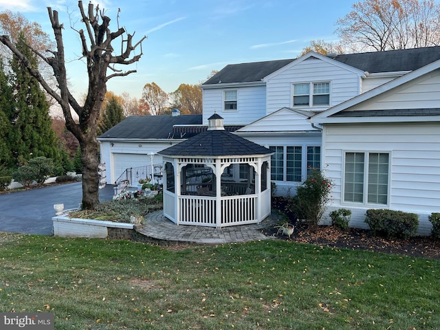 view of front of house featuring a garage, a gazebo, and a front yard